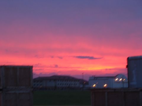 1988 Ford Bronco - A colorful sunset paints the sky over buildings and industrial containers.