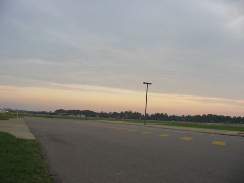 1988 Ford Bronco - A wide view of an empty parking lot under a cloudy sky at sunrise, with a single lamppost standing tall.