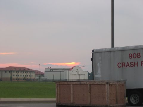 1988 Ford Bronco - A trailer is parked in front of buildings with a sunset in the background.