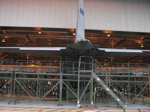 1988 Ford Bronco - The rear section of an aircraft is visible inside a large building, surrounded by maintenance platforms.