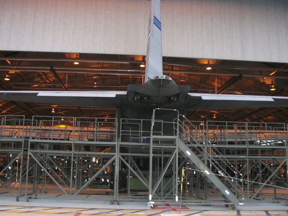 Airplane tail and wings inside a hangar, with scaffolding around it