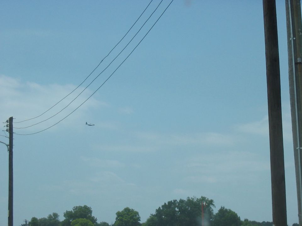 Airplane flying in a blue sky with power lines