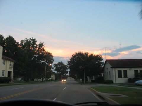 1988 Ford Bronco - A view of a road lined with buildings and trees during a colorful sunset.