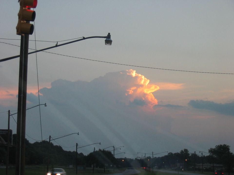 Sunset cloud formation over a road with traffic lights and street lamps