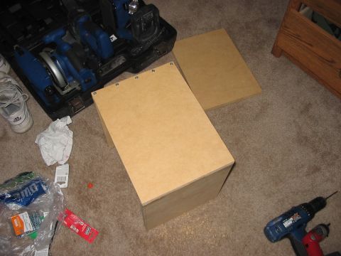 1988 Ford Bronco - Tools and unassembled wooden box components are laid out on a carpeted floor, suggesting a DIY project in progress.