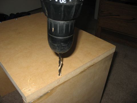 1988 Ford Bronco - A drill bit is shown boring into the surface of a particle board cabinet.