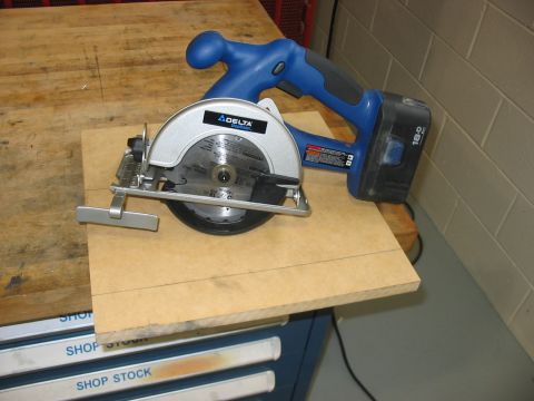 1988 Ford Bronco - A Delta cordless circular saw rests on a piece of particle board, ready for use.