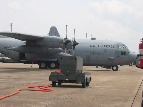 1988 Ford Bronco - A U.S. Air Force C-130 Hercules aircraft is parked on an airfield next to ground support equipment.