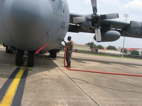 1988 Ford Bronco - A worker connects a hose to refuel a large military transport aircraft parked on the tarmac.