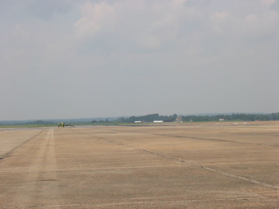 Yellow vehicle on airport tarmac, distant view
