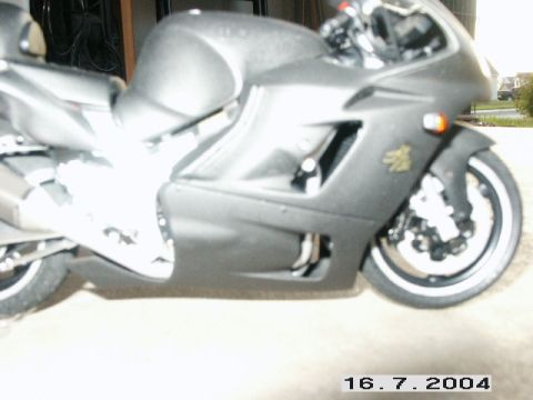 1998 Mercury Sable - A dark gray motorcycle is parked, with its front wheel and side fairing clearly visible.