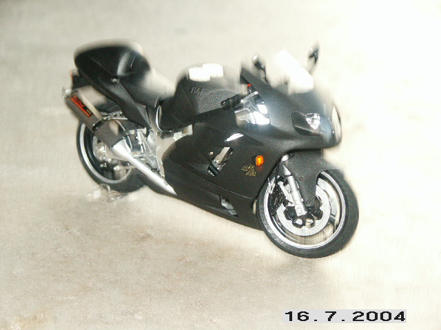 Black sport motorcycle with chrome exhaust and visible engine components