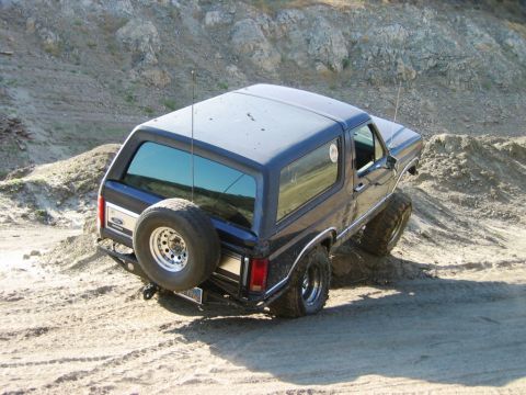 1985 Ford Bronco - This 1985 Ford Bronco navigates a challenging dirt incline, its off-road capabilities.