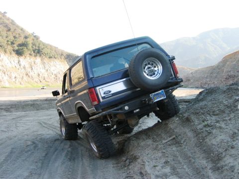1985 Ford Bronco - This 1985 Ford Bronco navigates a steep dirt incline, its off-road capabilities.