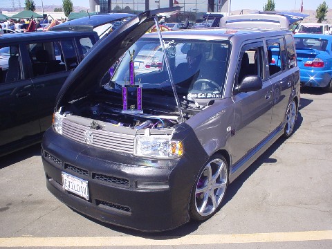 1993 Ford Taurus - Modified Scion xB on display with hood open, trophies visible in engine bay.