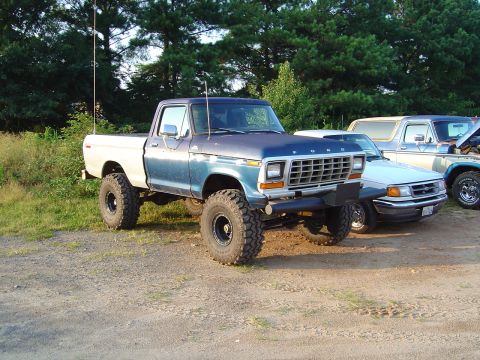 1986 Ford Bronco - A lifted 1979 Ford pickup truck is parked outdoors with other vehicles behind it.