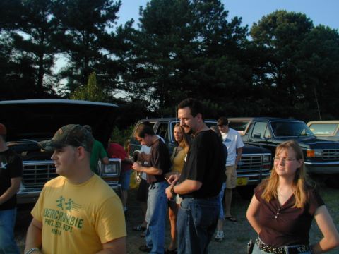 1988 Ford Bronco - Several people are gathered around a Ford F-Series truck with its hood up.