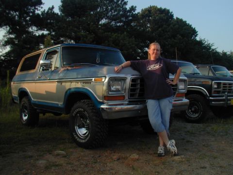 1988 Ford Bronco - Woman poses with a 1978 Ford Bronco, a second Bronco is visible in the background.