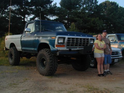 1988 Ford Bronco - A lifted Ford F-Series truck is parked outdoors with two people standing next to it.
