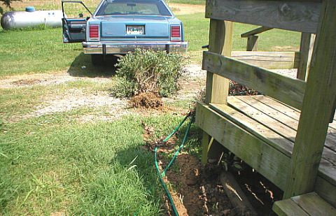 1987 Ford Crown Victoria LTD - The rear of a blue 1987 Ford Crown Victoria LTD is visible with its driver's door open.