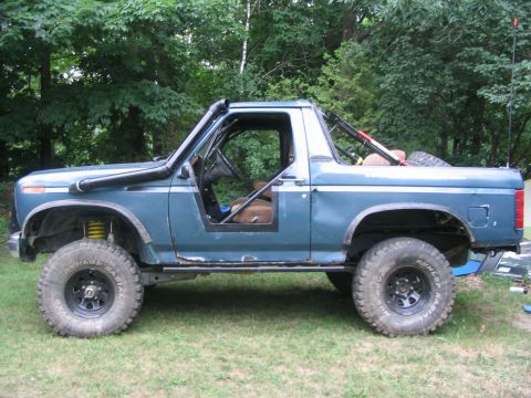 1986 Ford Bronco - This modified SUV features a snorkel, roll cage, and large off-road tires, suggesting it's built for terrain.