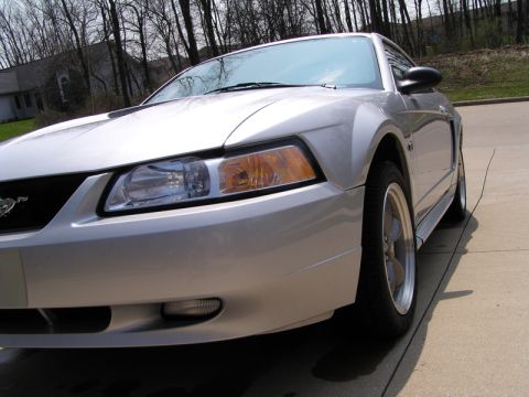 2000 Ford Mustang - This silver 2000 Ford Mustang coupe is captured from a 3/4 front angle, highlighting its distinctive body style.
