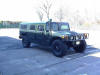1990 Ford Bronco - A green Humvee is parked outdoors on a sunny day.