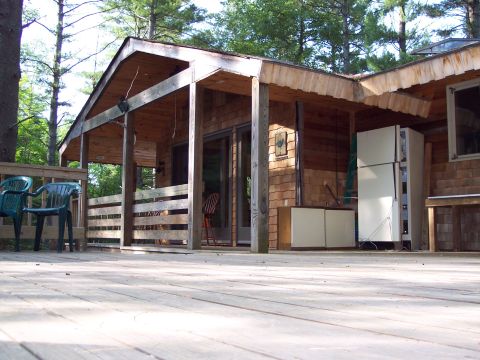 2001 Ford Crown Victoria - Exterior view of a wooden cabin with a deck, showing outdoor appliances and seating.