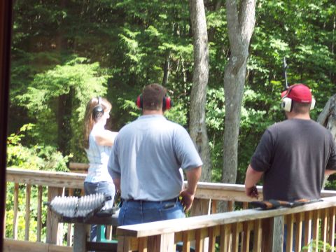 2001 Ford Crown Victoria - People enjoy a day outdoors on a wooden deck, with lush green trees providing a natural backdrop.