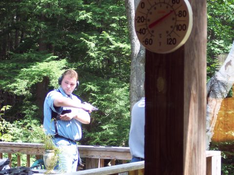 2001 Ford Crown Victoria - A man practices with a handgun on a deck, with a thermometer visible in the background.