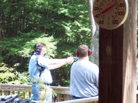 2001 Ford Crown Victoria - Men practice shooting handguns on a deck, with a thermometer visible on a wooden post.
