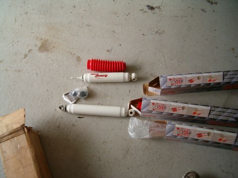 1991 Ford Bronco - New Rancho RS5000 shock absorbers and a red dust boot are laid out on a concrete surface.