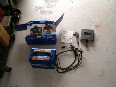 1991 Ford Bronco - Welding equipment, including a machine, mask, and brush, is displayed on a garage floor.