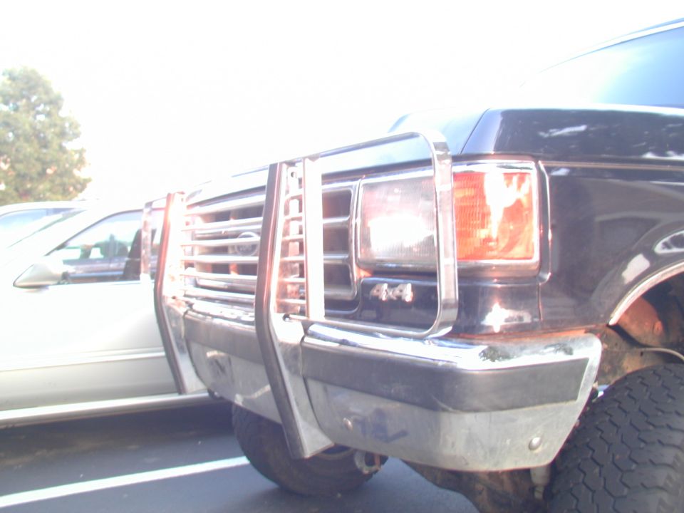 Close-up of a dark Ford truck front end with chrome brush guard and 4x4 badge