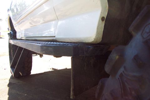 1996 Ford Bronco - Vehicle's rock slider step boards and tire are shown in this close-up side view.