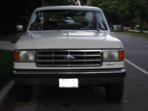 1988 Ford Bronco - This white Ford truck's grille and headlight design suggest a model year around 1987, not 1988.