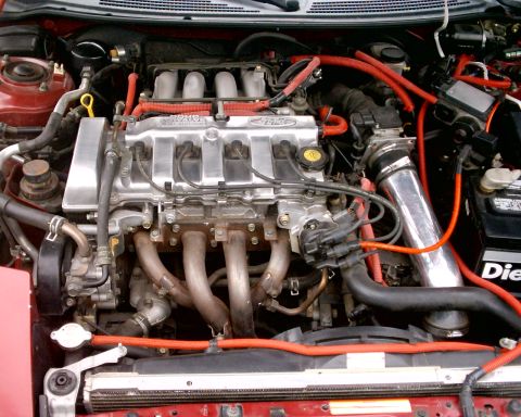 1994 Ford Probe - The engine bay of a car is shown with various components and red hoses.