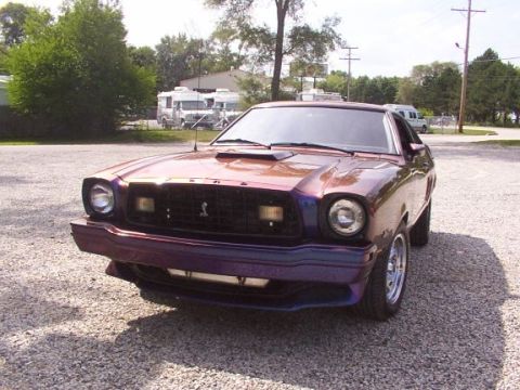 1978 Ford Mustang II - A 1978 Ford Mustang II with a custom iridescent paint job is parked on a gravel lot.