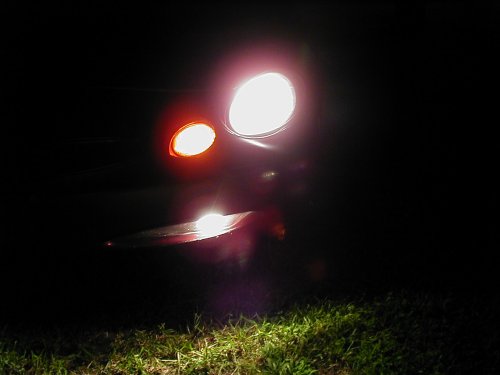 1997 Ford Taurus headlight and amber turn signal illuminated at night