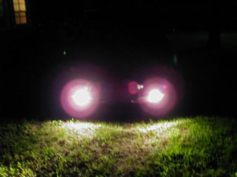 1997 Ford Taurus - Headlights illuminate a grassy area in the dark, with a building visible in the background.