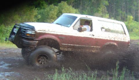 1993 Ford Bronco - This 1993 Ford Bronco is tackling a muddy trail, with its tires deep in the muck.