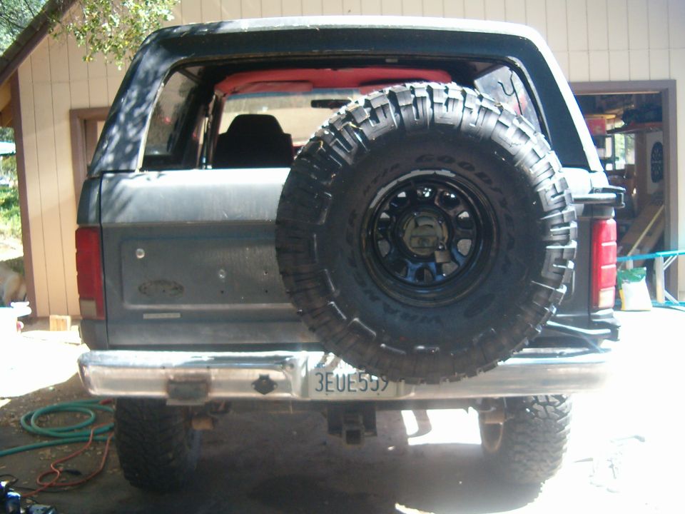 Rear of gray Ford Bronco with large Goodyear Wrangler spare tire on tailgate carrier, plate 3EUE559
