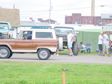 1979 Ford Bronco - A classic Ford Bronco is parked at an outdoor event with other vehicles and people nearby.