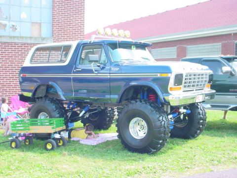 1979 Ford Bronco - A modified 1978 Ford Bronco sits on display next to another truck.