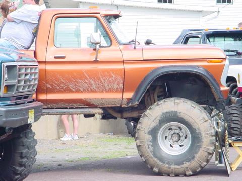 1979 Ford Bronco - This lifted pickup truck, likely from the late 1970s, is shown parked next to another vehicle with a trophy nearby.