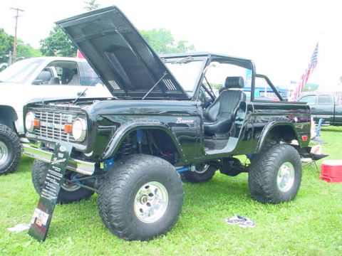 1979 Ford Bronco - Modified 1979 Ford Bronco on display with its hood raised, showing off its engine bay and suspension.