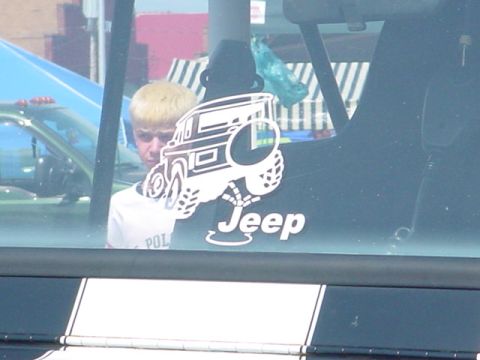 1979 Ford Bronco - A sticker depicting a Jeep is affixed to the rear window of a vehicle, with a person visible in the background.