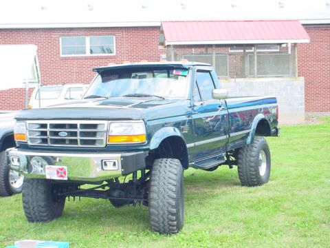 1979 Ford Bronco - This lifted pickup truck is shown from the front quarter angle, with a visible license plate.