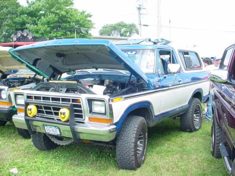 1979 Ford Bronco - 1979 Ford Bronco on display with its hood open, parked outdoors on a grassy area.