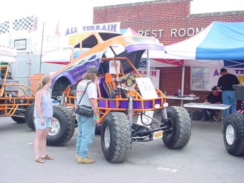 1979 Ford Bronco - A custom-built off-road vehicle with vibrant paintwork is displayed outdoors, with spectators and other vehicles present.